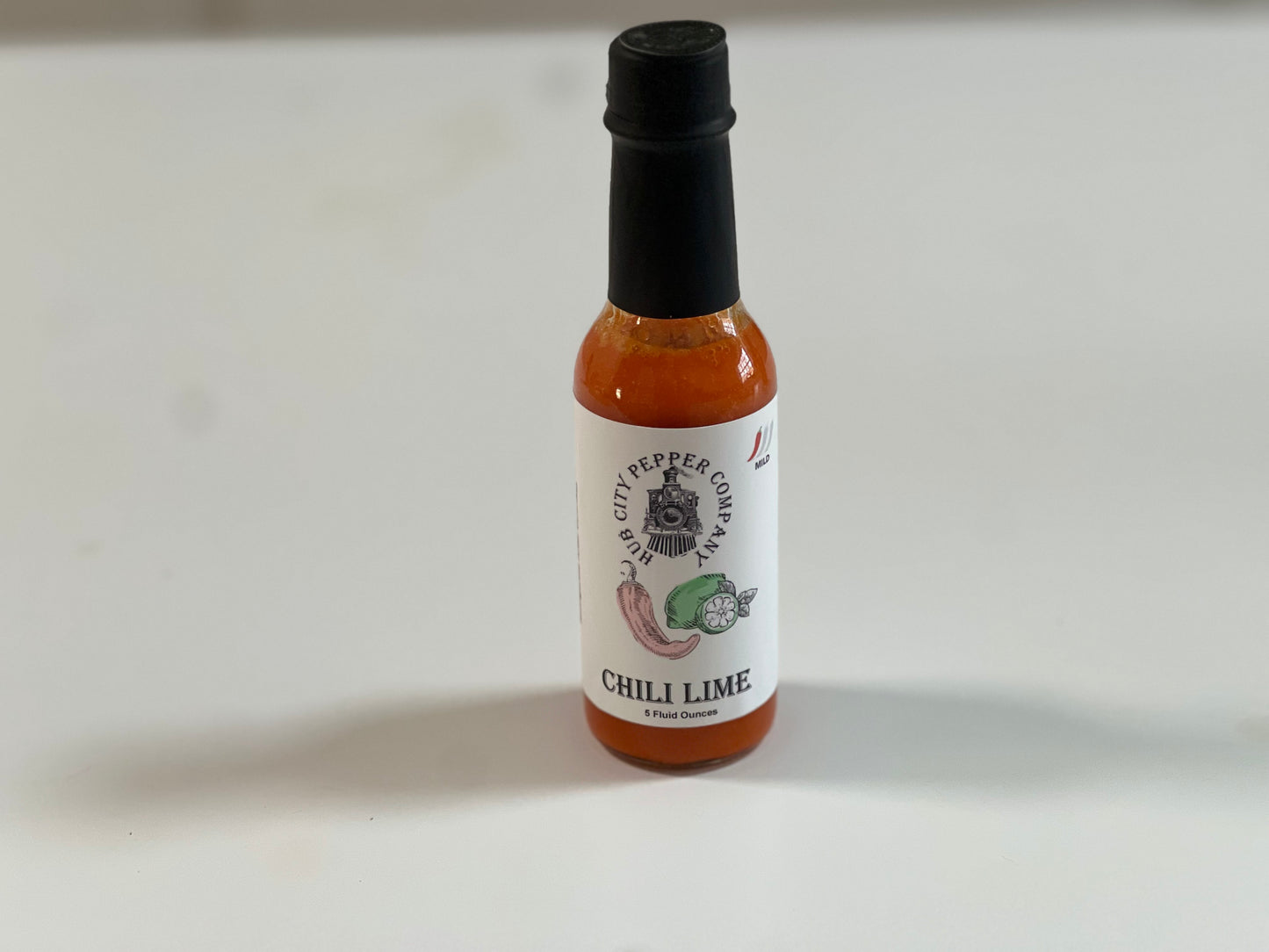 Chili Lime Hot Sauce. A tangy and spicy hot sauce. Sitting on counter shot.